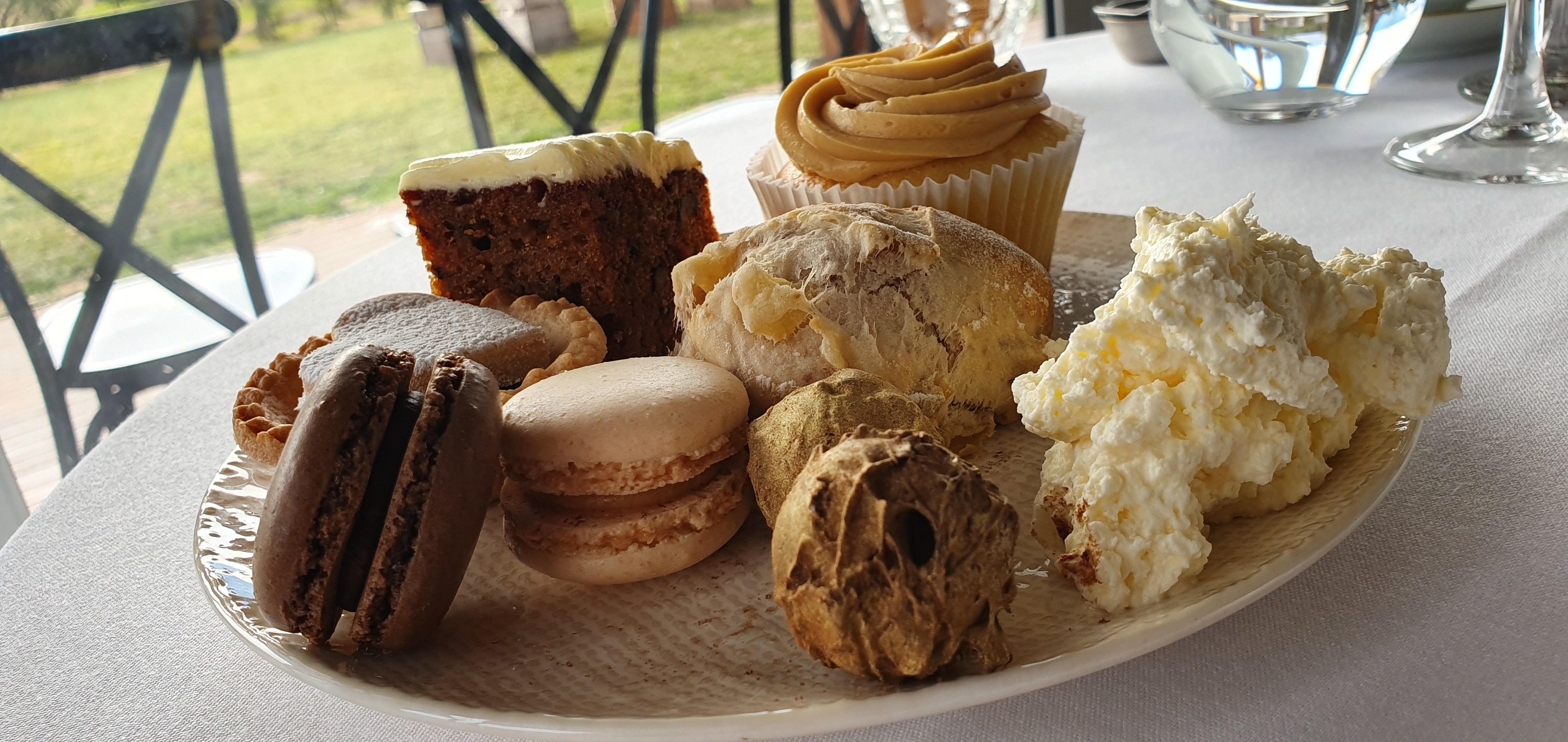 Clockwise from left: chocolate and vanilla macarons, raspberry tarts, carrot cake, apple and walnut scone, caramel cup cakes, peach jam and whipped cream, gold-dusted chocolate truffles.