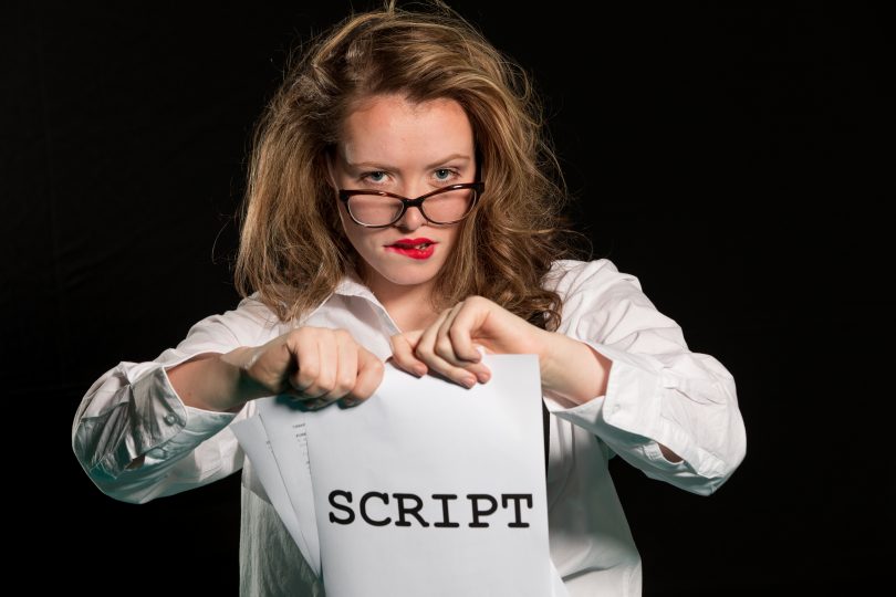 Photograph of woman tearing script in half