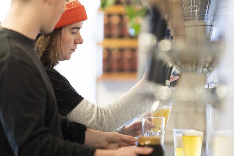 Staff pouring beer at Capital Brewing Co taproom.