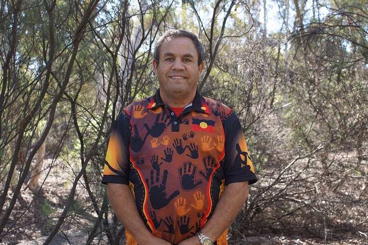 Larry Brandy Aboriginal Storyteller standing in bushland.
