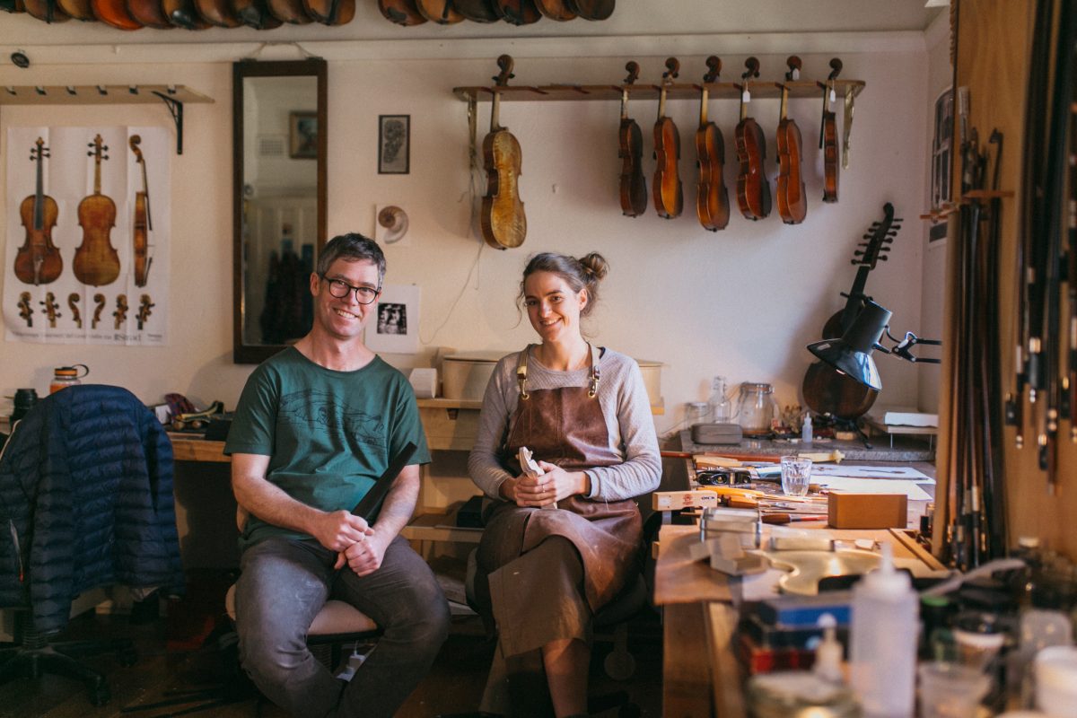 man and woman in violin-making studio