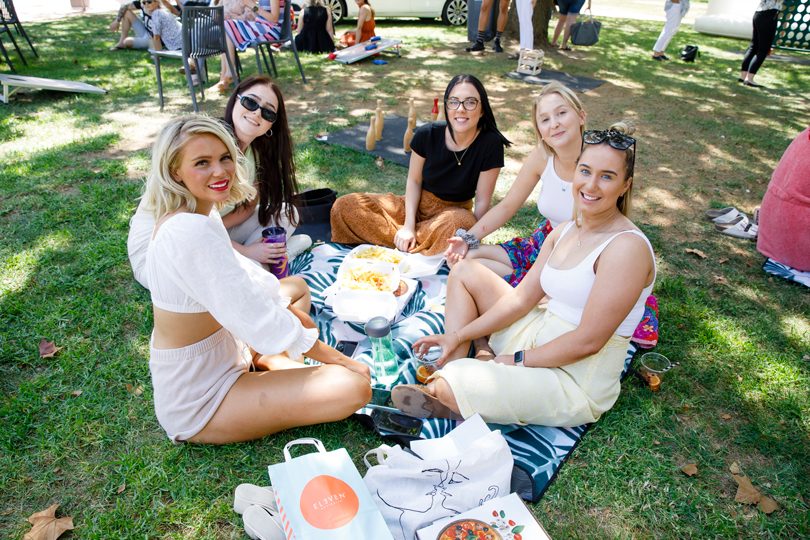 Group of women having picnic on lawn