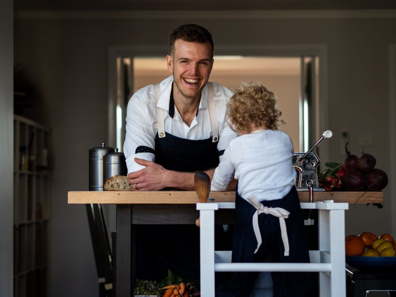 Man at a kitchen bench with child facing the other way