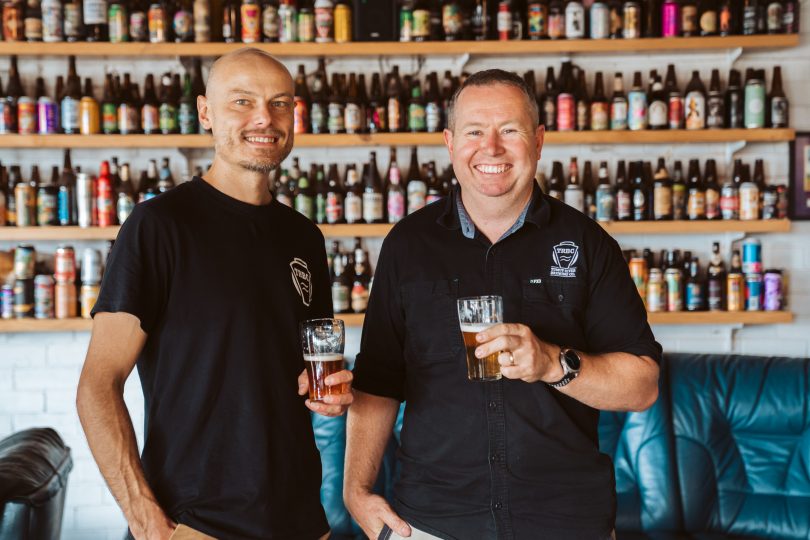 Michael Cichocki and Tim Martin holding beers the brewery