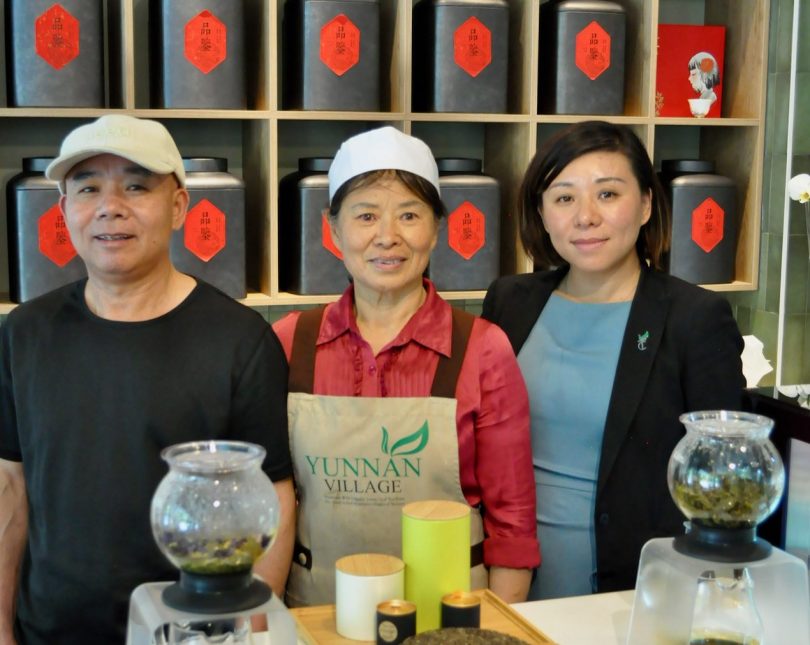 Coco's family stands in front of tea cannisters