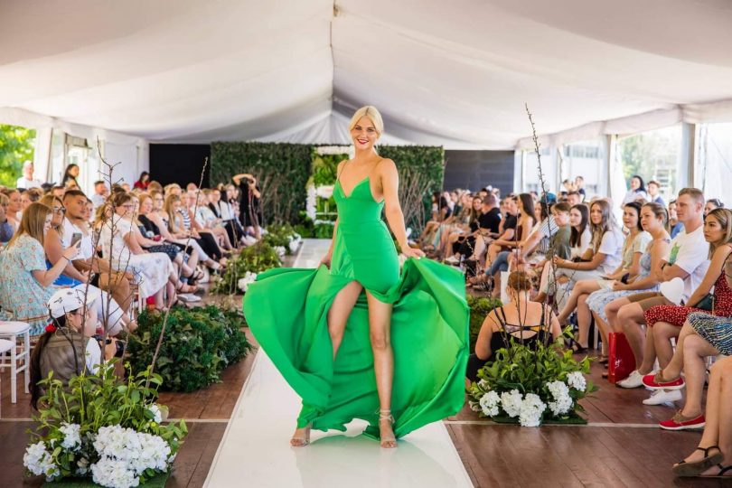 Model in green dress on fashion runway