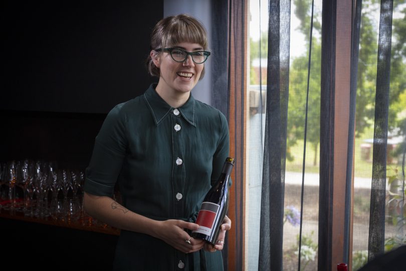 Caitlin Bakers holds a bottle of wine