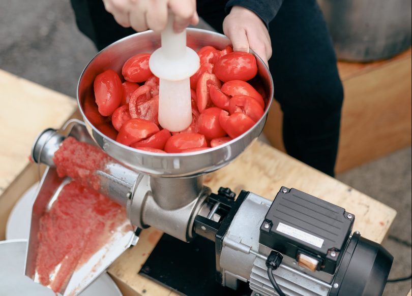 Tomatoes being crushed into passata