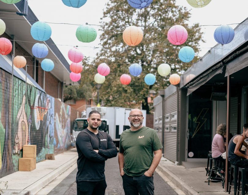 Two men standing in an alleyway 