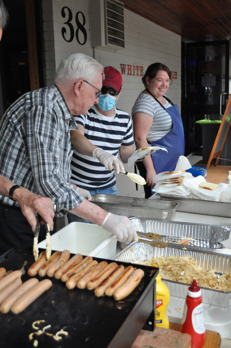 Volunteers serve sausages