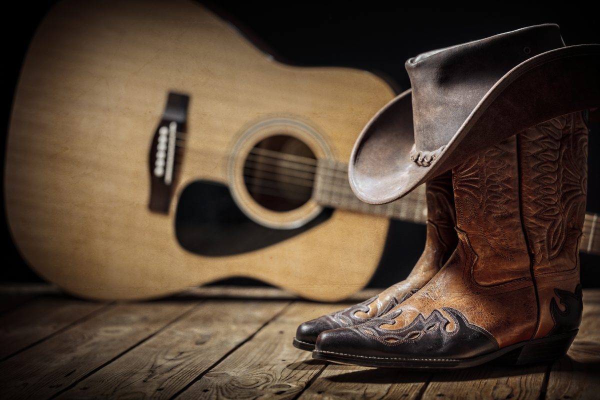acoustic guitar with cowboy hat and boots background