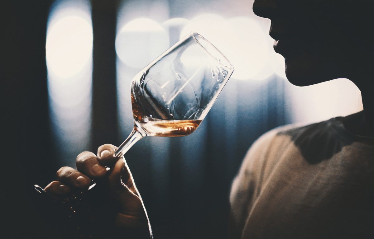Silhouette of person tasting wine