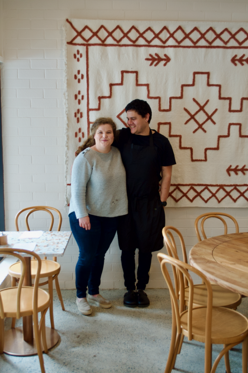 Two people pose in cafe
