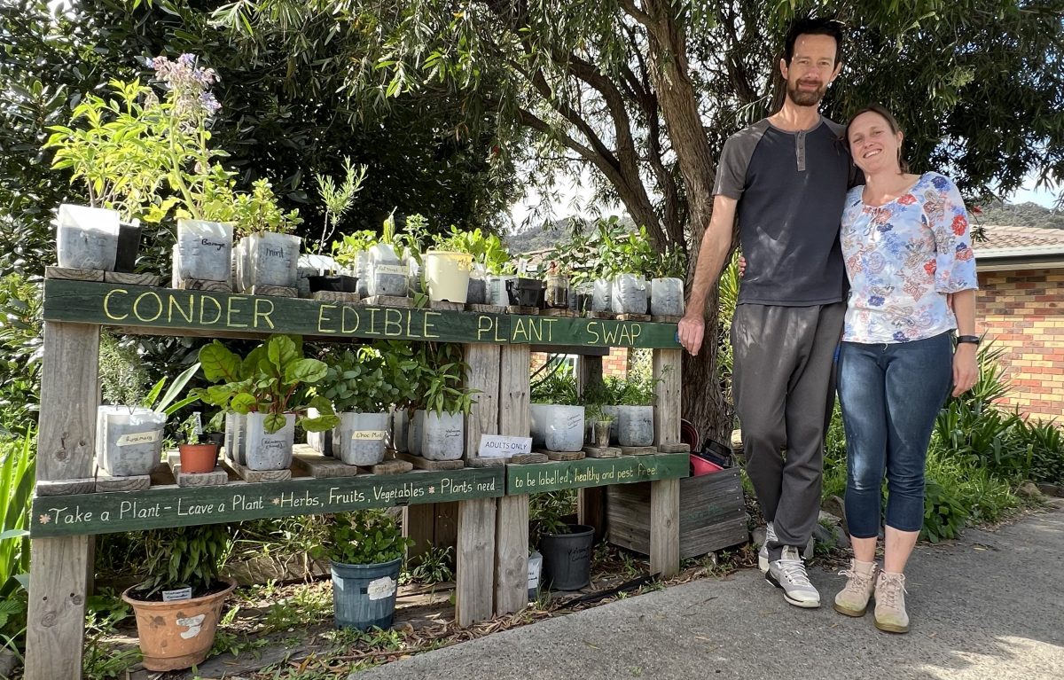 Two people next to a plant stall