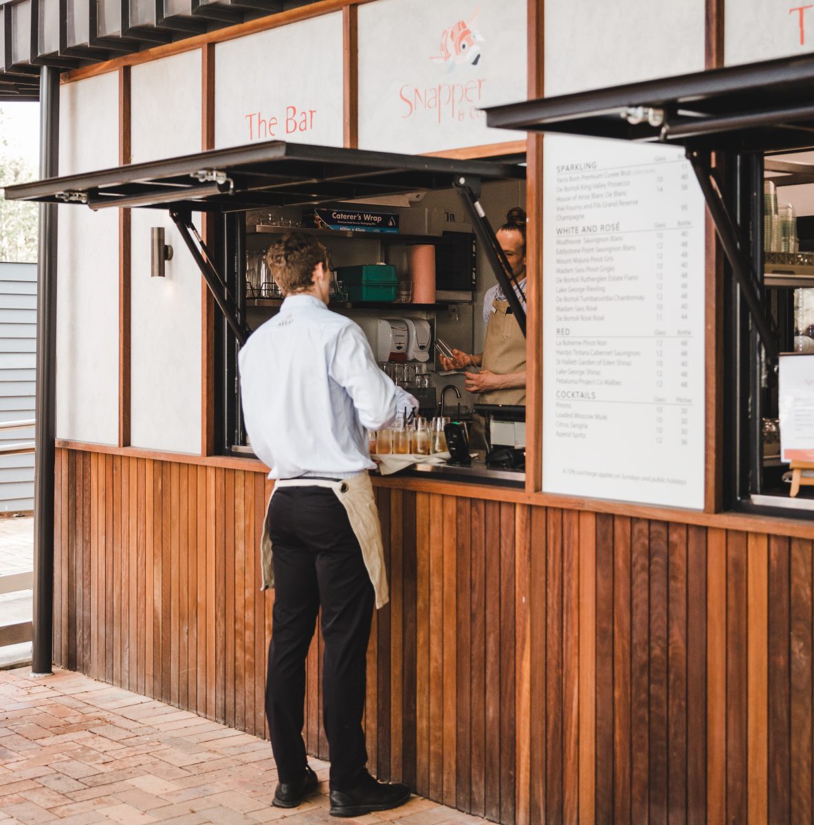 Waiter picks up cold beverages at the bar at Snapper and Co in Yarralumla