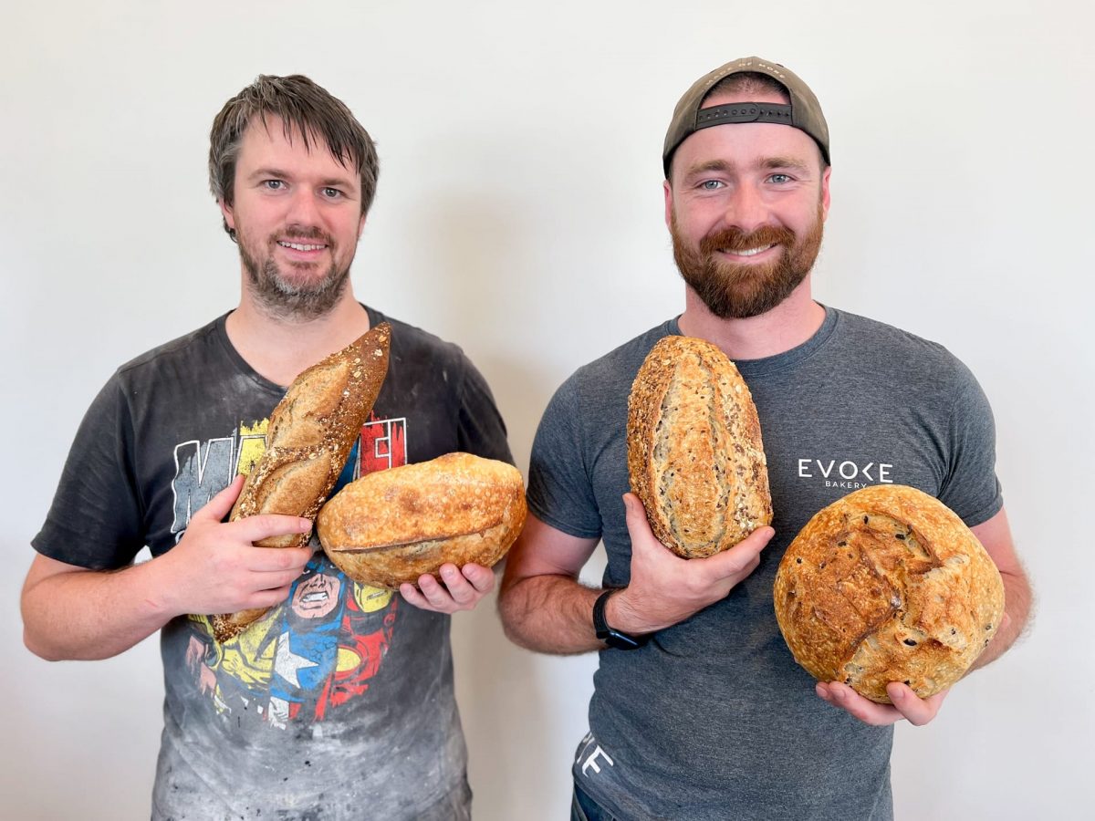 two men holding bread