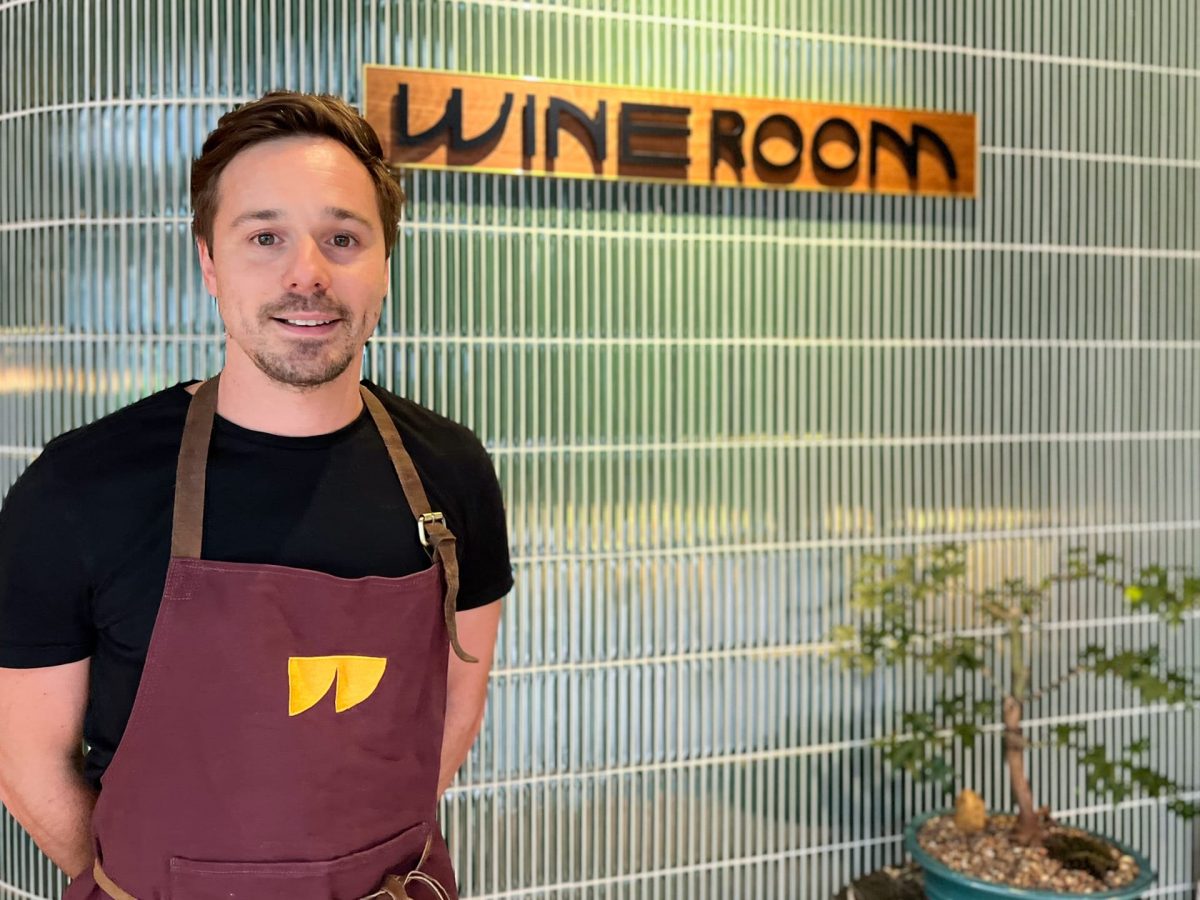 Paolo Sossi in front of Wine Room logo