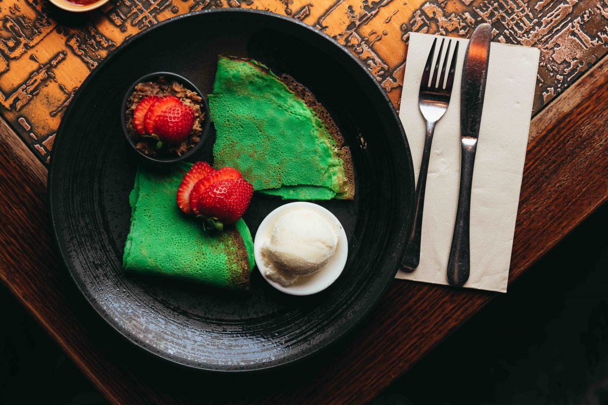 Bright green crepes served with strawberries