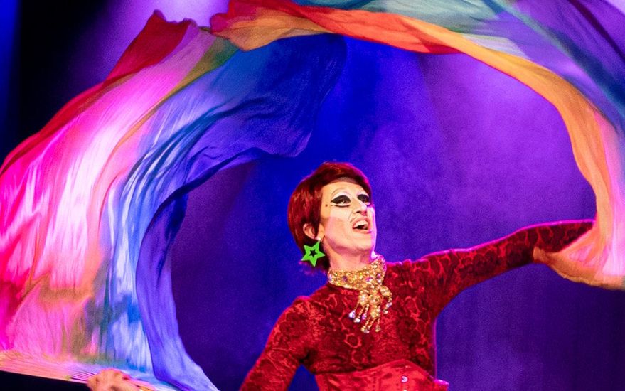 Drag king Guy Alias swirls colourful fabric in an arc