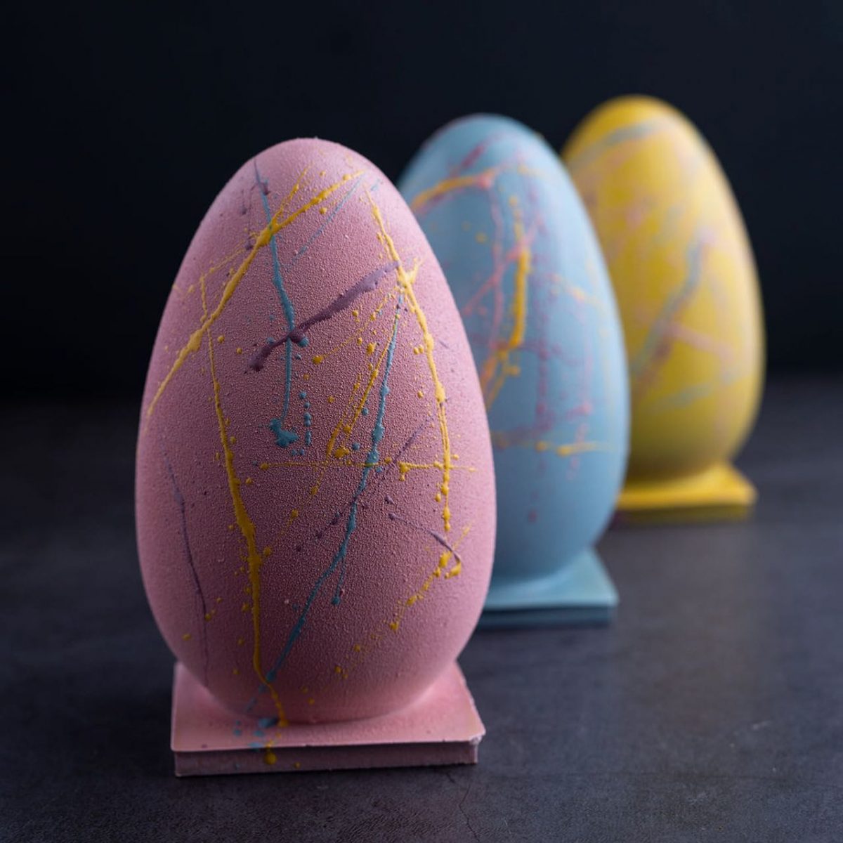 A pink, blue and yellow pastel easter egg flecked with the other colours.