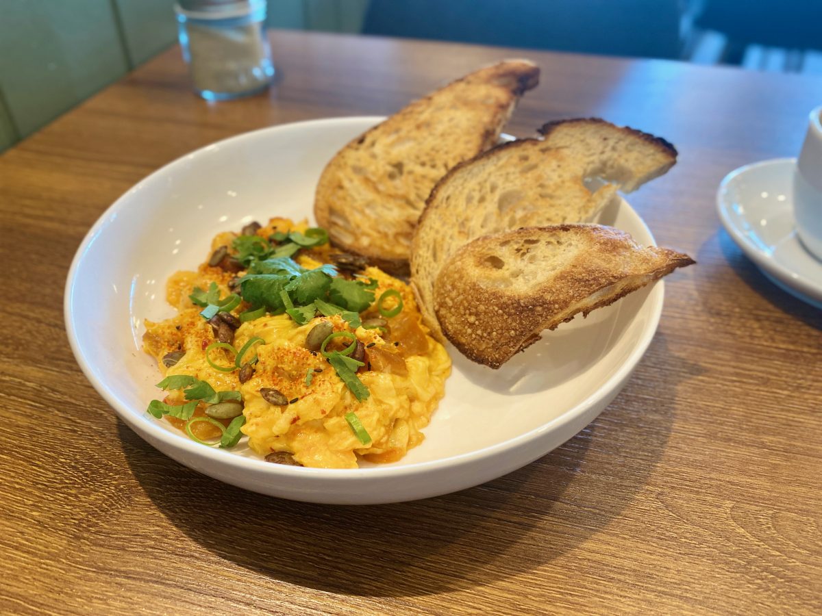 Scrambled eggs topped with chili and herbs, served with toast.