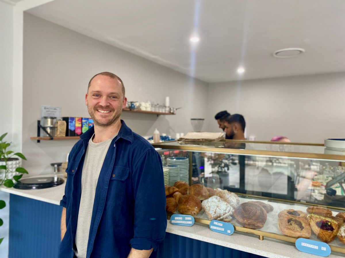 man stands in front of cafe counter