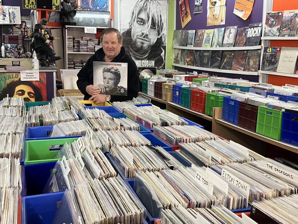 Phil Place in Dynomite Records holding a David Bowie album