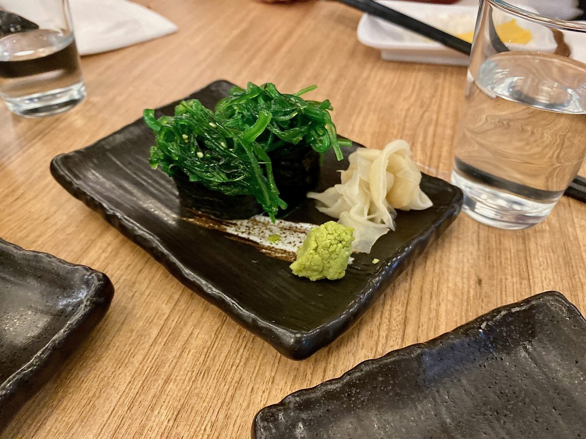 plate of sushi with brightgreen wakame seaweed.