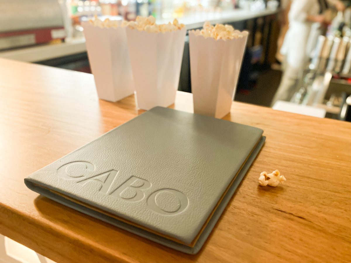 Cabo menu with popcorn in the background.