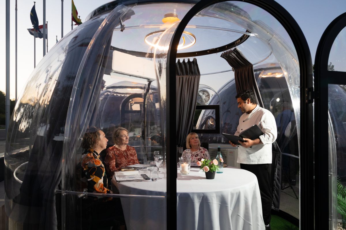 people sitting at table inside a dining dome