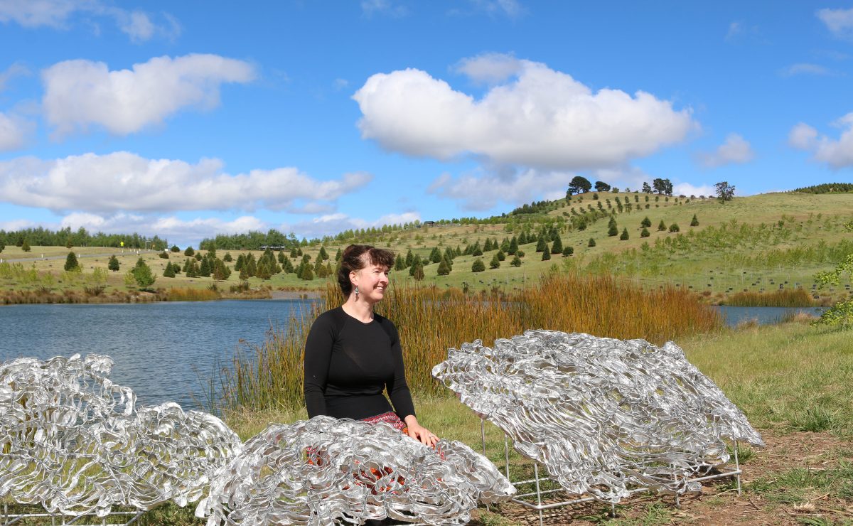 Hannah Quinlivan with model of artwork near dam