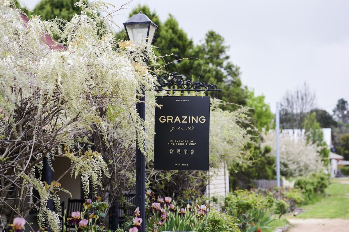 Grazing restaurant sign with flowering wisteria