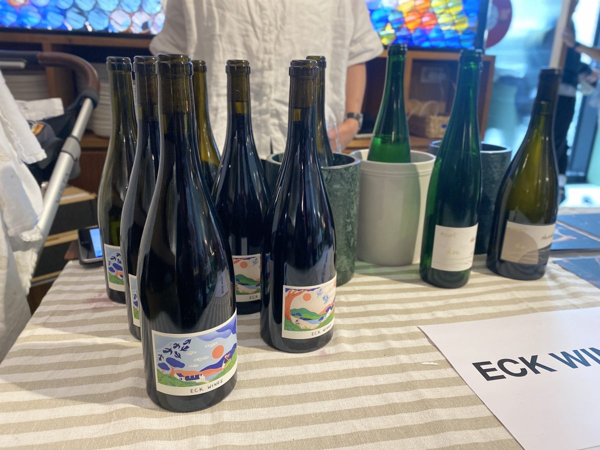 Bottles of wine with colourful lables and a sign that says "Eck".