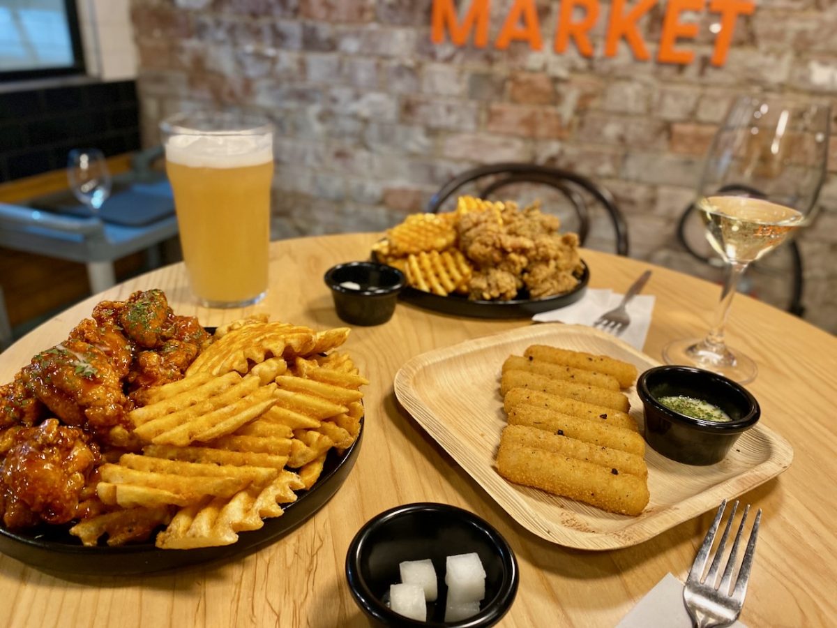 Table of food featuring fried chicken, waffle fries and beer.