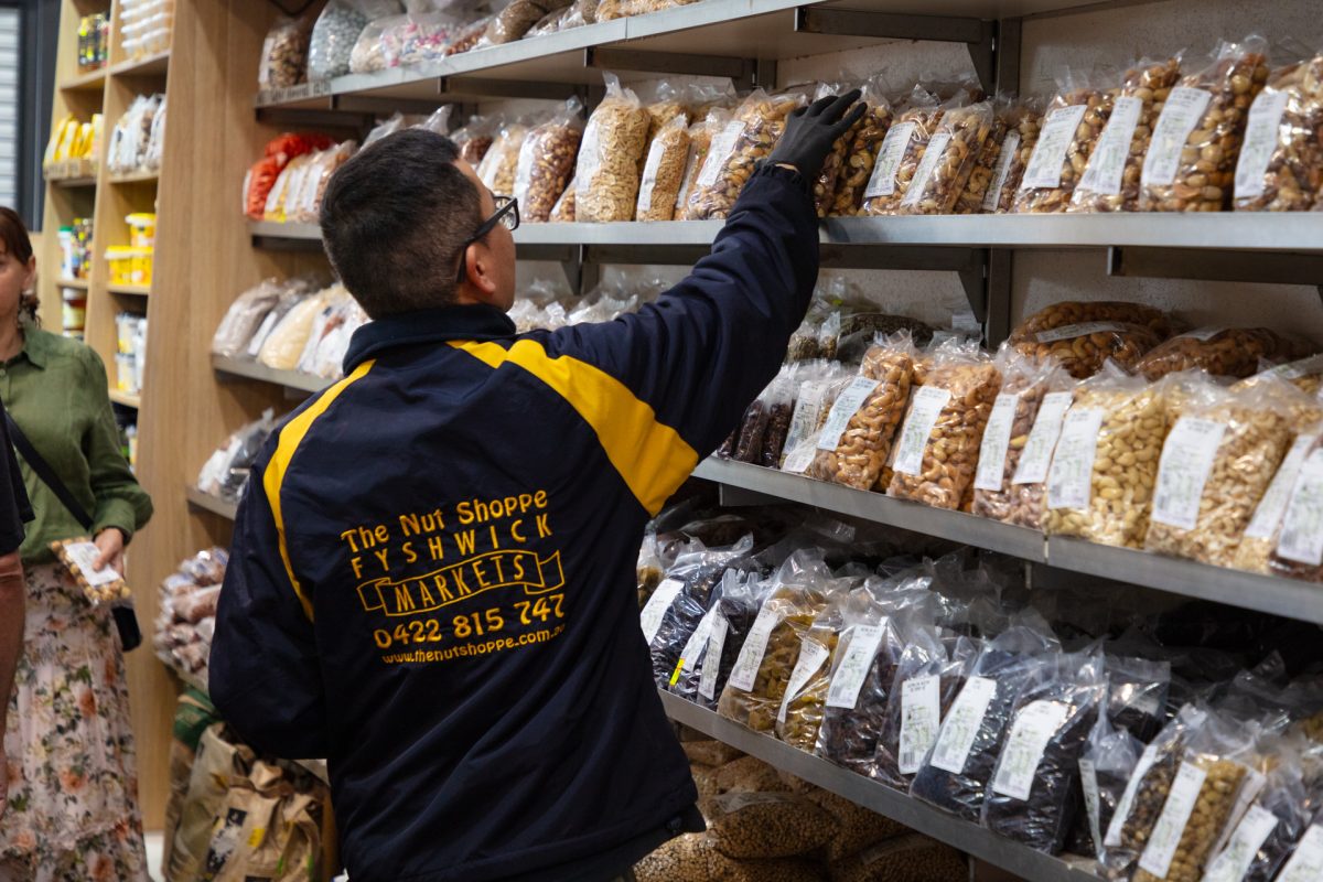 A Nut Shoppe staff member packs shelves