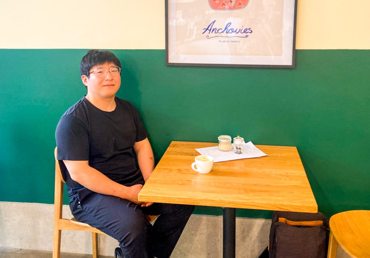 Nicky Kim sits at a table in his cafe