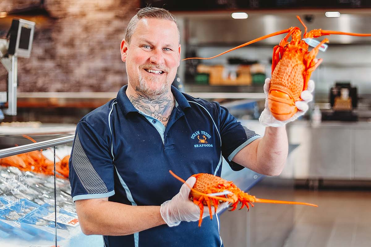 Nick from Ocean Fresh Seafood holding two lobsters