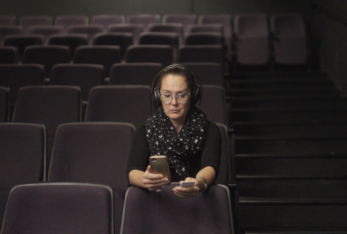 Woman using a smartphone while wearing headphones