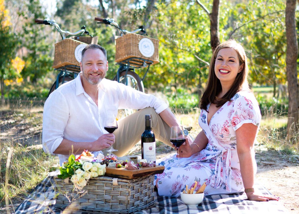 two people on a picnic with a charcuterie board and wine