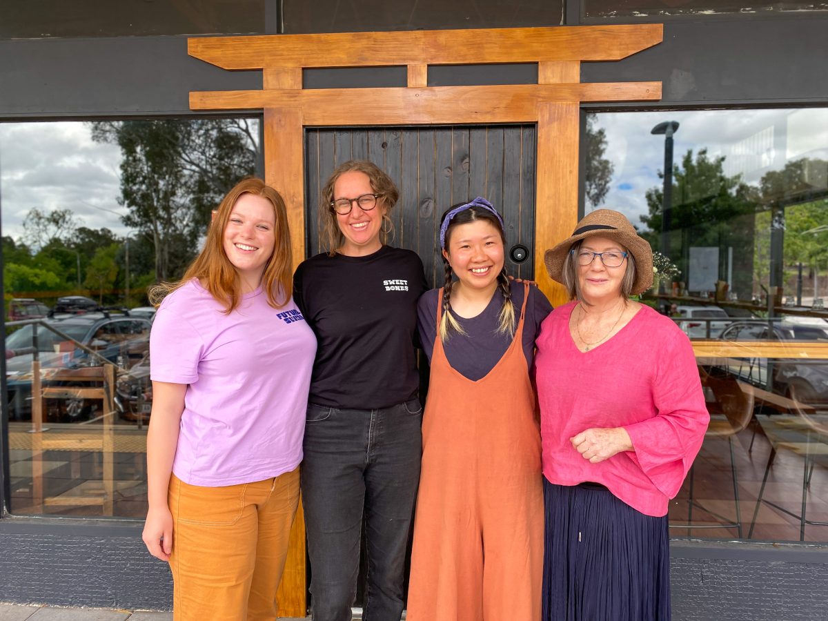Four women standing in front of a restaurant.