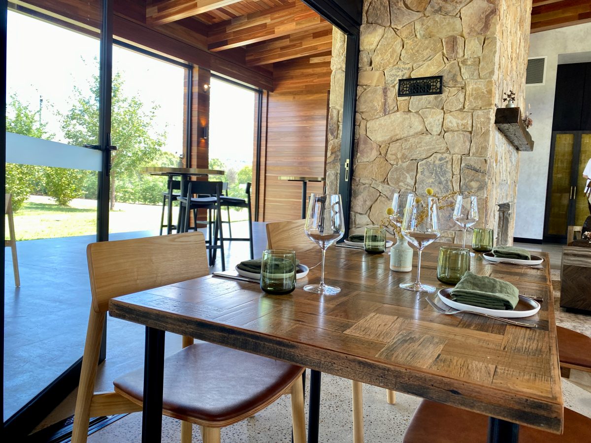 Restaurant table set next to feature stone wall.