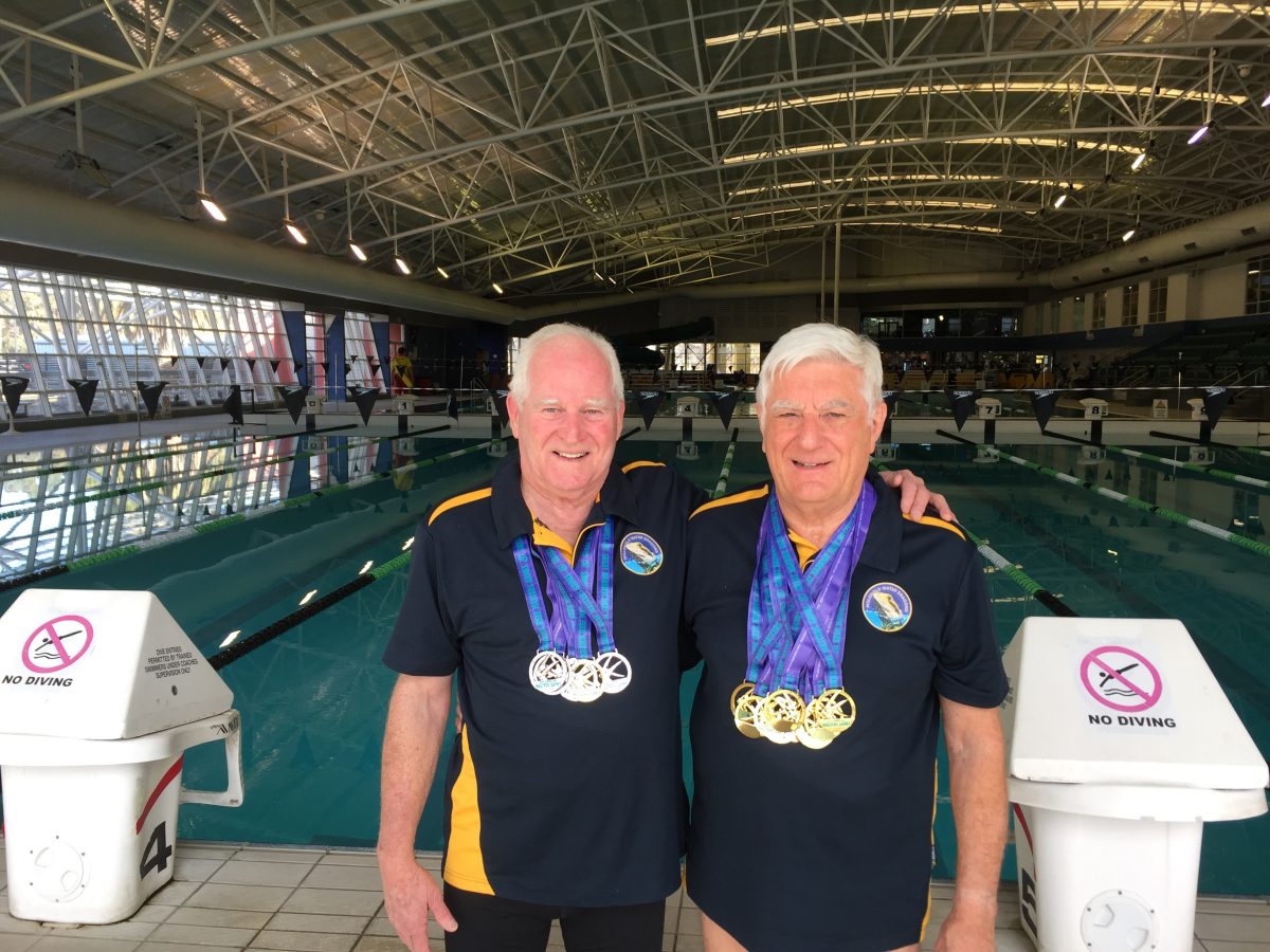 two men standing near an Olympic pool