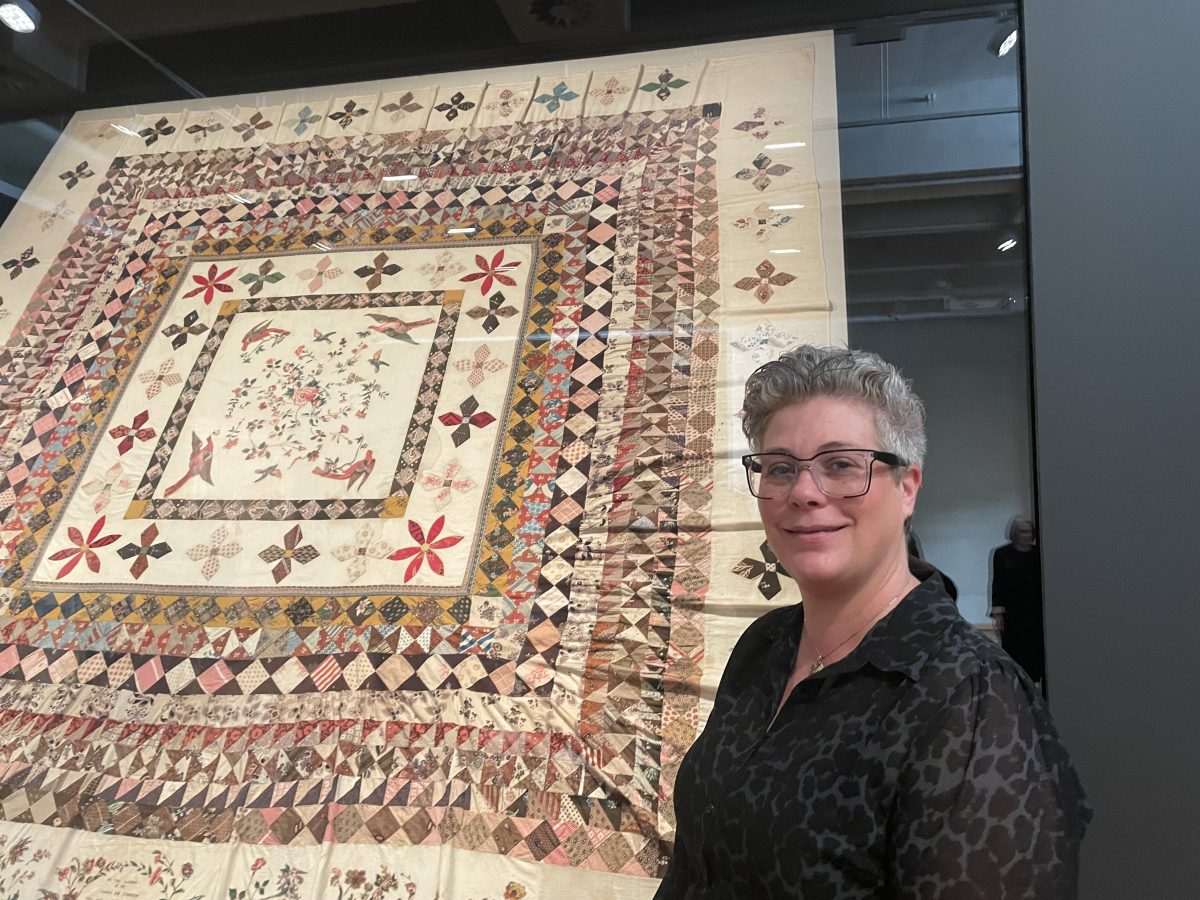 Woman standing in front of quilt