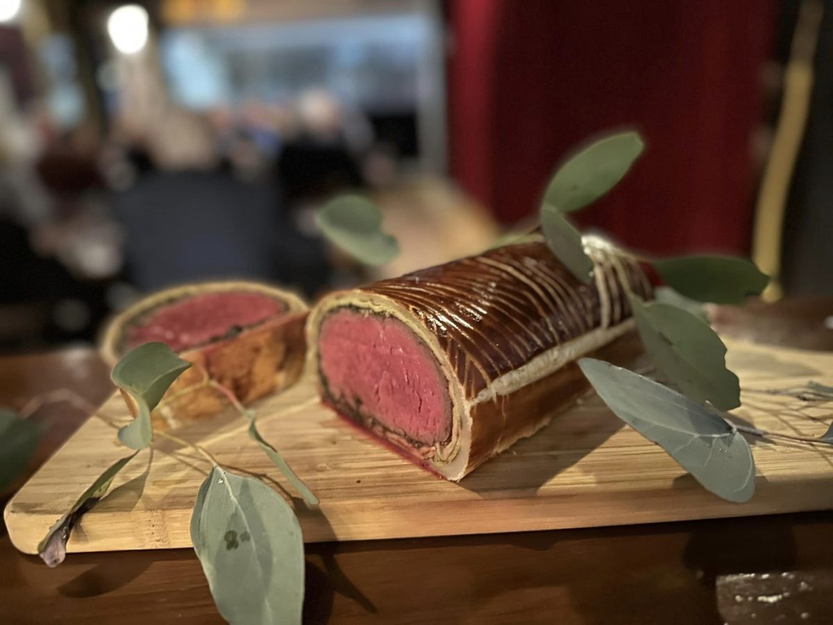 roll of cooked beef on a board