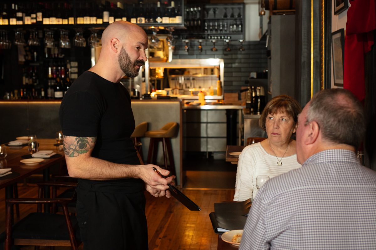 chef talking to couple on a table