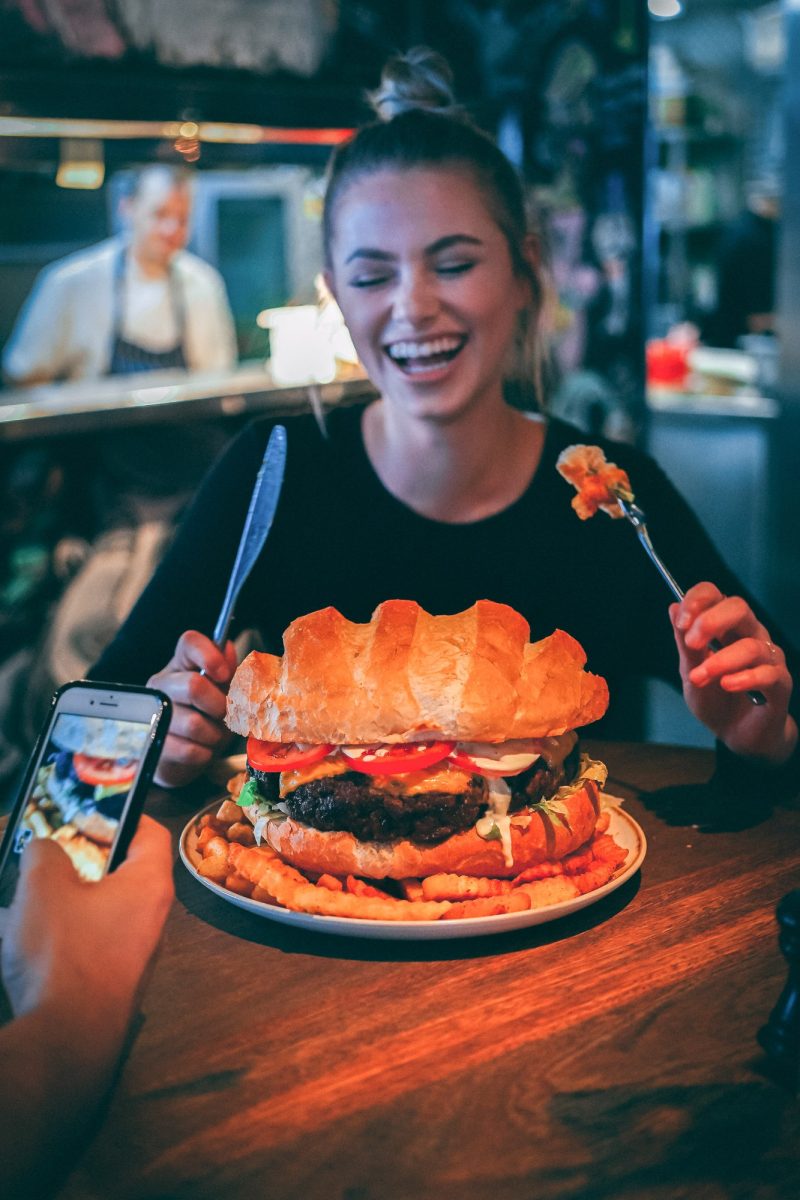woman eating a really huuuuuuuuuge burger