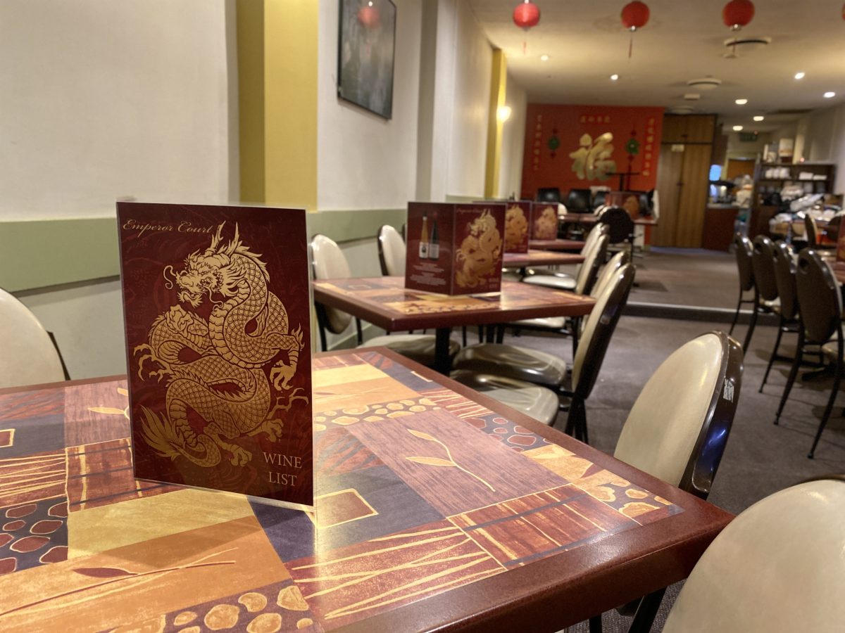Red menu with golden dragon on restaurant table.