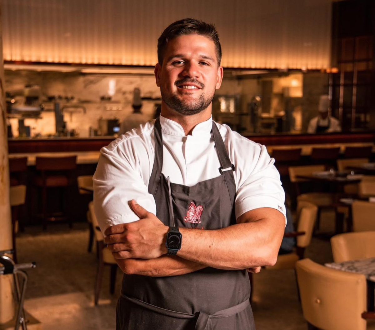 Smiling chef in white jacket and apron