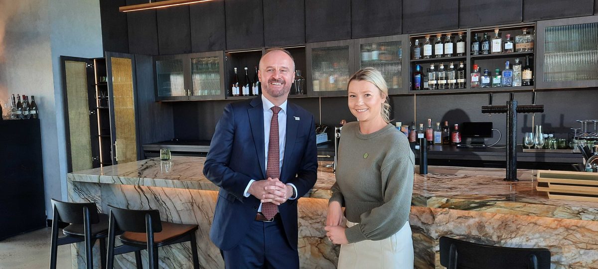 Andrew Barr and a woman leaning against a bar