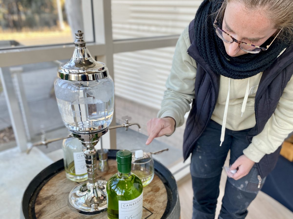 Woman setting up absinthe fountain.